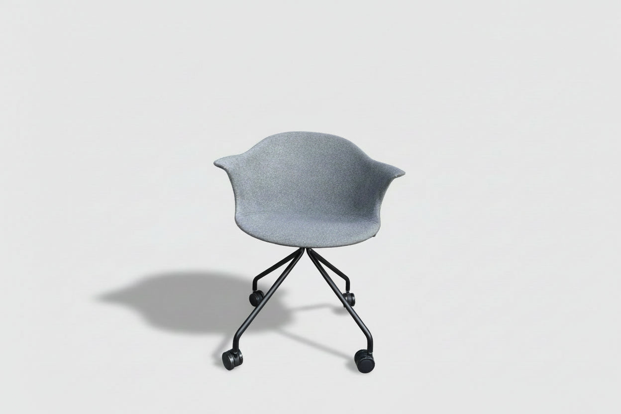 Gray leaf-shaped planter with a black stand against a building and window background