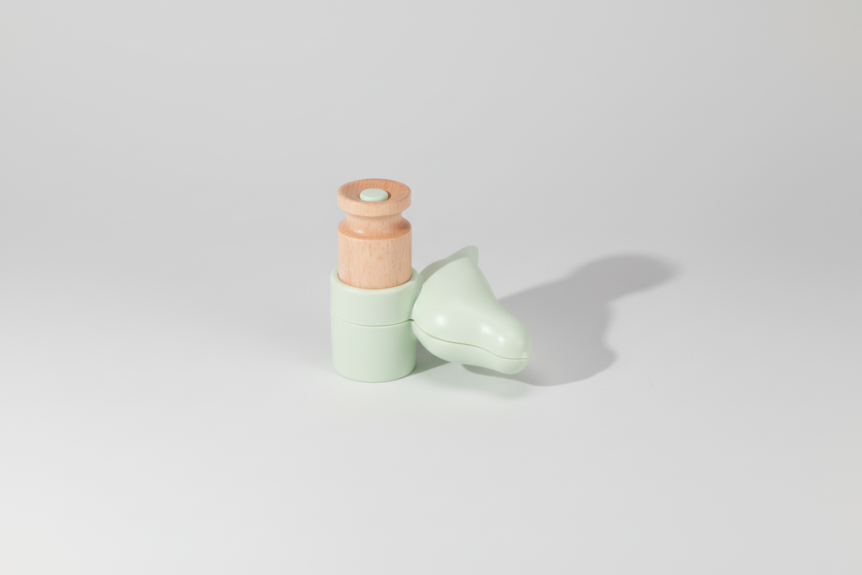 Wooden toy horse with a green base on a white background