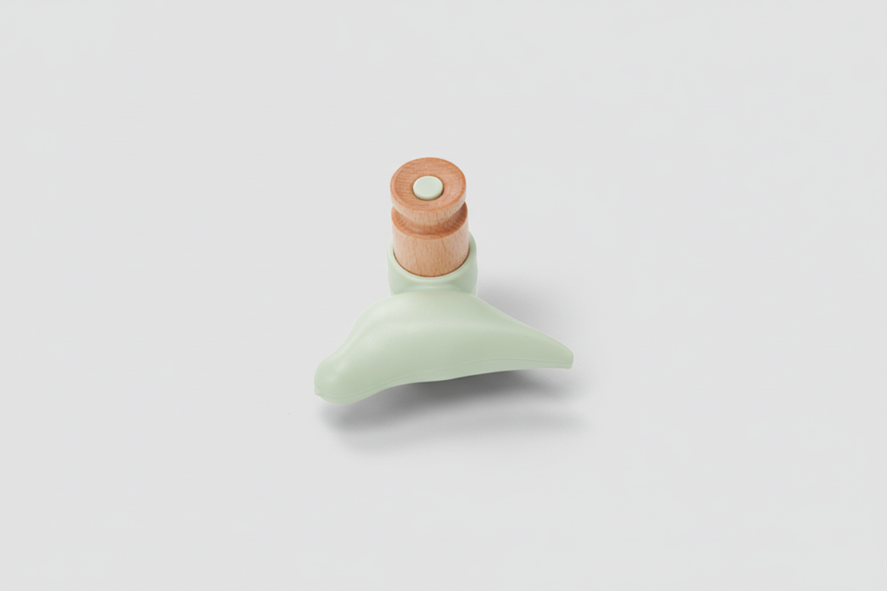 Green toy with a wooden top on a white background