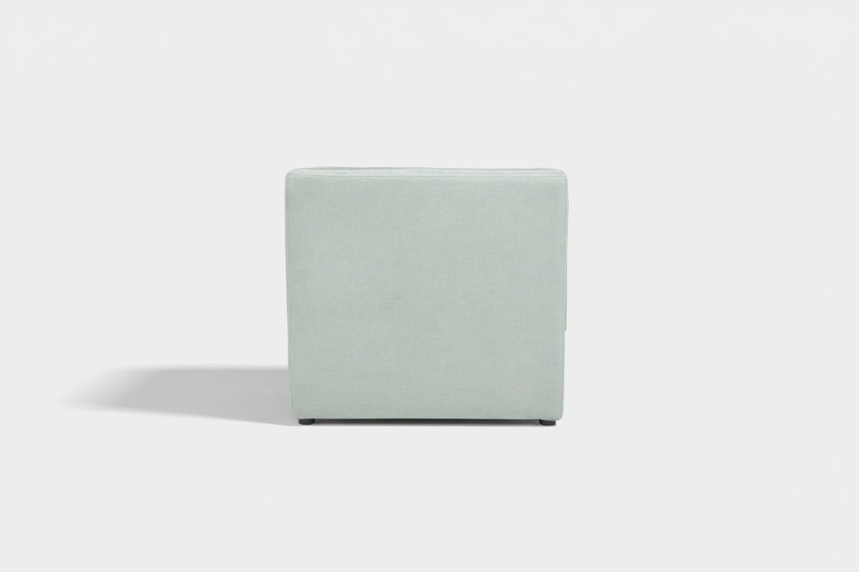 Light gray cube-shaped ottoman on a white background