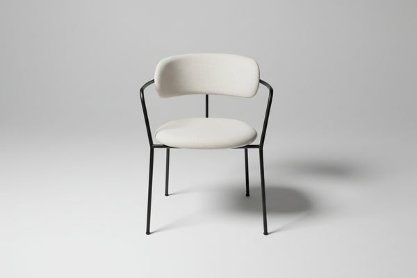 White chair with black metal frame on a gray pavement