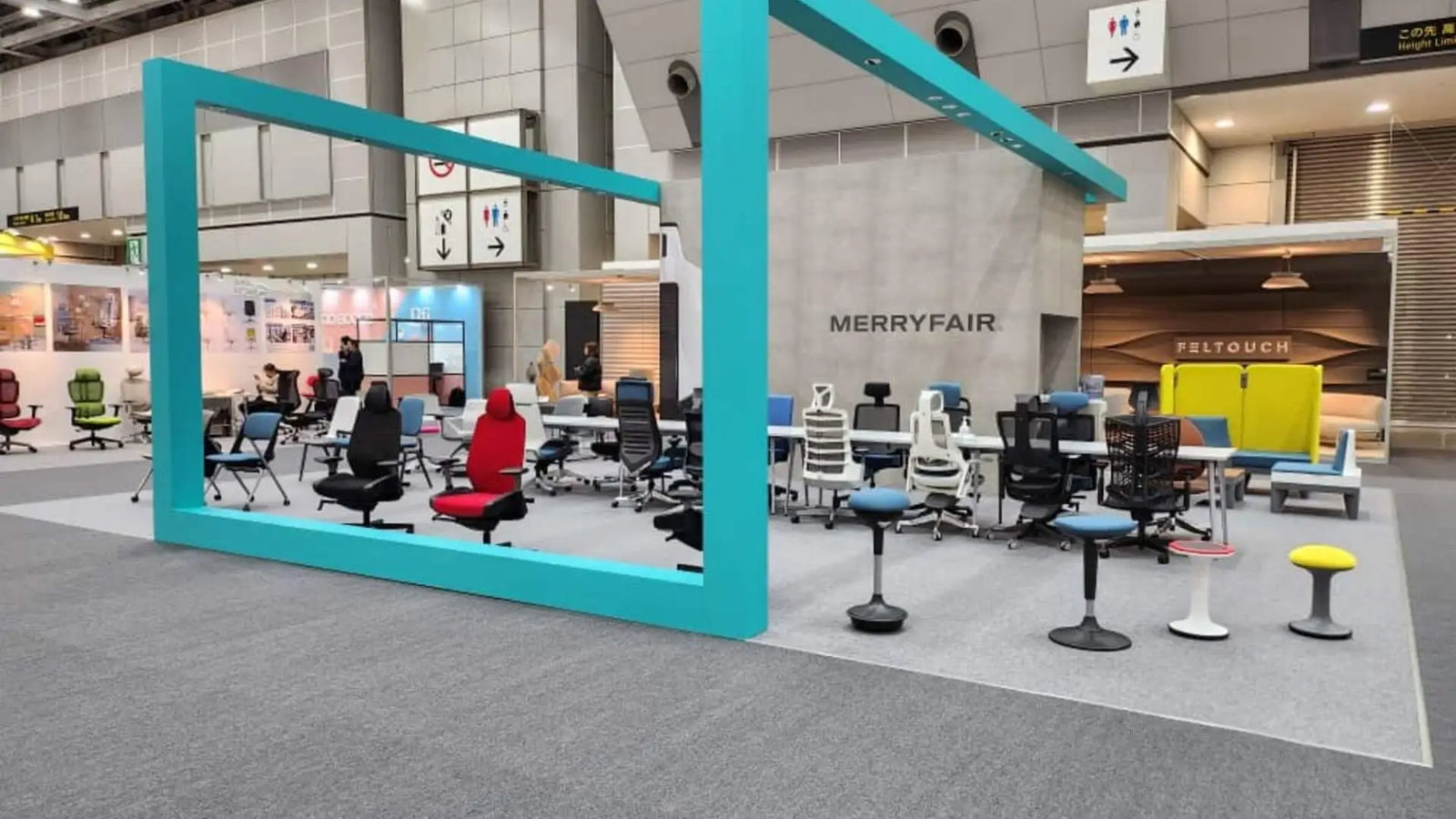 Modern office space with colorful chairs and a large turquoise frame.